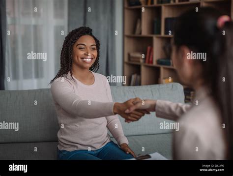 Happy African American Millennial Female Shaking Hands With European