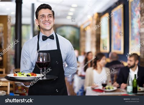 Portrait Of Smiling Waiter With A Serving Tray In The R Royalty Free