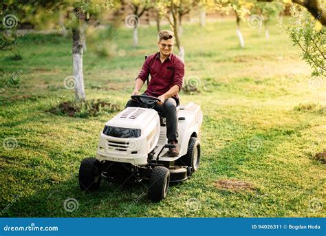 Man Worker Using Ride On Lawnmower Male Riding Lawn Tractor And