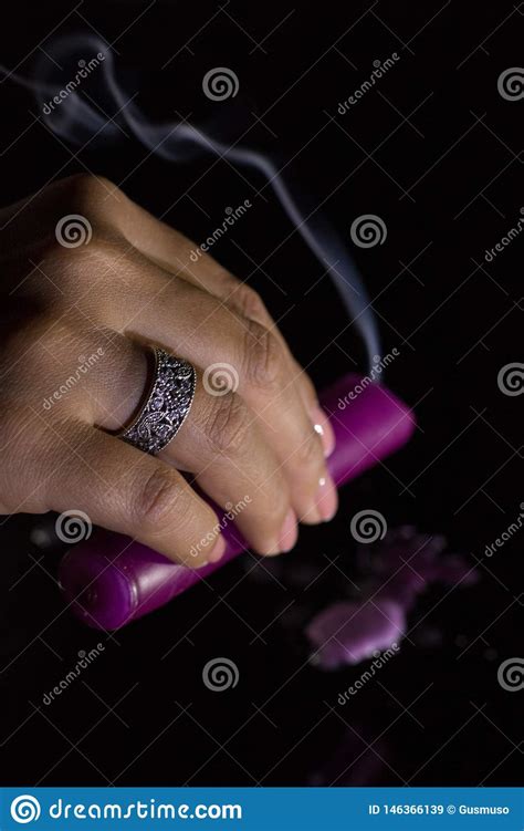 De Hand Van Een Vrouw Met Een Mooie Zilveren Ring Houdt Een Rokende Purpere Kaars Stock