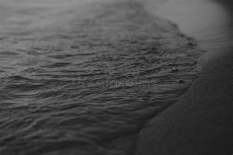 closeup black and white shot of ocean water and a sandy beach in daylight stock image image of