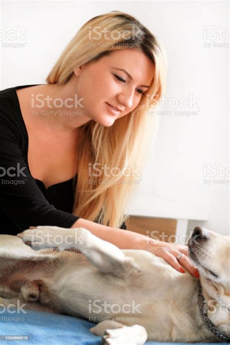 Woman With Her Dog In Bed At Home Relaxing In Bedroom Beautiful Girl Is