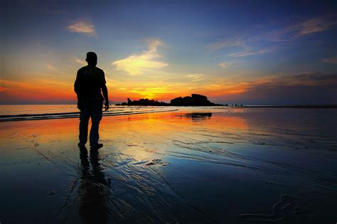 Silhouette Of Man Standing Beside Ocean During Sunset · Free Stock Photo