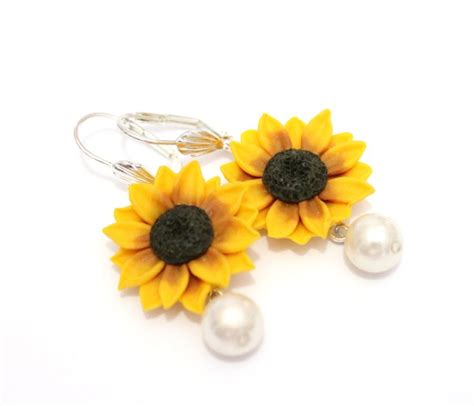Two Sunflowers And Pearls Are Hanging From Earrings