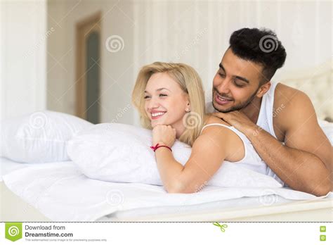 Young Couple Lying In Bed Happy Smile Hispanic Man And Woman Stock