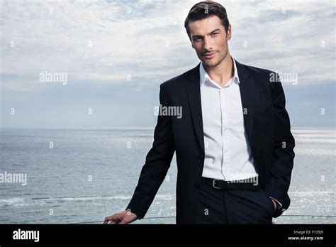 Handsome Businessman Standing Outdoors With Sea On Background Stock