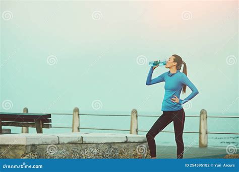 Stay Well Hydrated While Running A Young Woman Drinking Water After