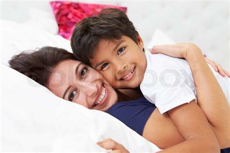 mother and son lying in bed together stock image colourbox