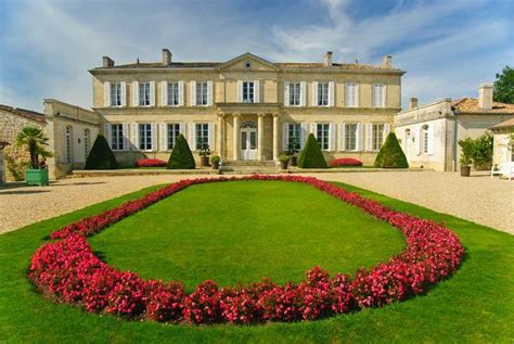 A Large House With Lots Of Flowers In The Front Yard