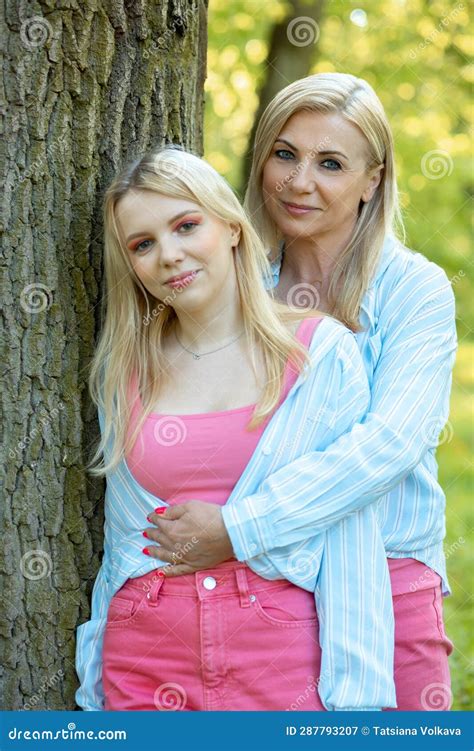 mother s love two smiling blonde mom and daughter dressed identically are standing in park