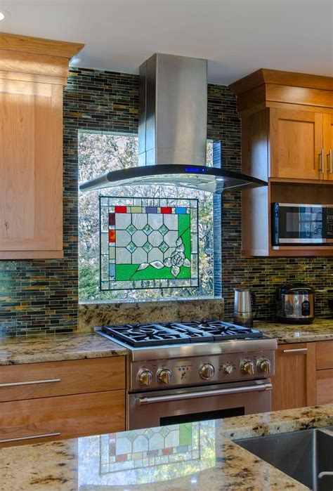 Orange mosaic backsplash tiles add a stunning accent to the white cabinetry in this kitchen with a blue central island that's fitted with a porcelain sink and chrome fixtures. Backsplash Ideas - multi colored tile backsplash, thermal ...