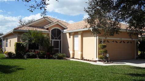 This painted beige brick stands out against a black front door, and grey washed shingled roof. What to Consider When You Paint Your Sarasota House