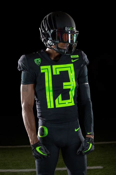 A Football Player Wearing A Black Uniform And Neon Green Gloves On The