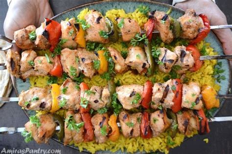 Hands Reaching Out With A Big Platter Of Middle Eastern Chicken Kabobs