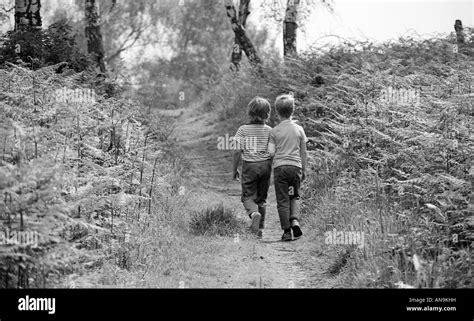 Two Boys Walking Along A Woodland Path Stock Photo Alamy