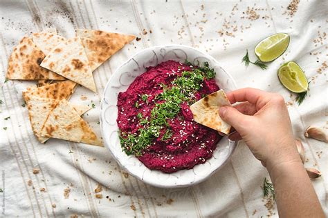 Eating Beet Dip With Tortilla Chips By Stocksy Contributor Pixel