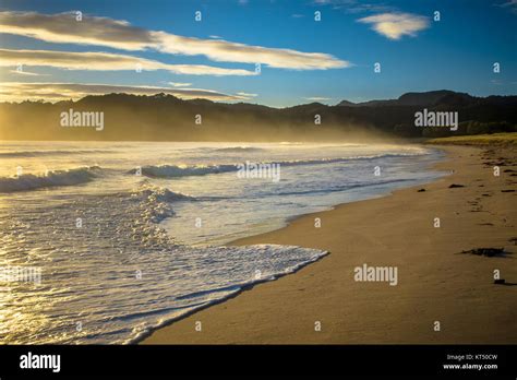 Sunrise Over The Ocean Waves On Waikawau Bay Beach New Zealand Stock