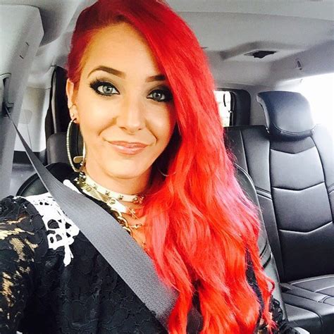 A Woman With Long Red Hair Sitting In The Back Seat Of A Car Smiling