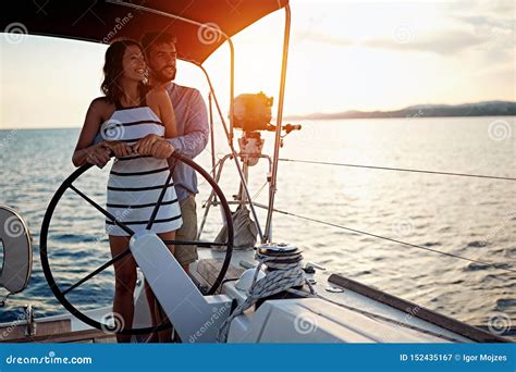 Romantic Couple Sailing On The Luxury Boat Together And Enjoy At Sunset