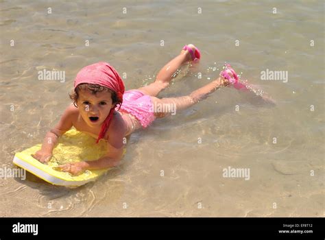 Girl Lying In Shallows On The Beach With Her Kick Board And Diving