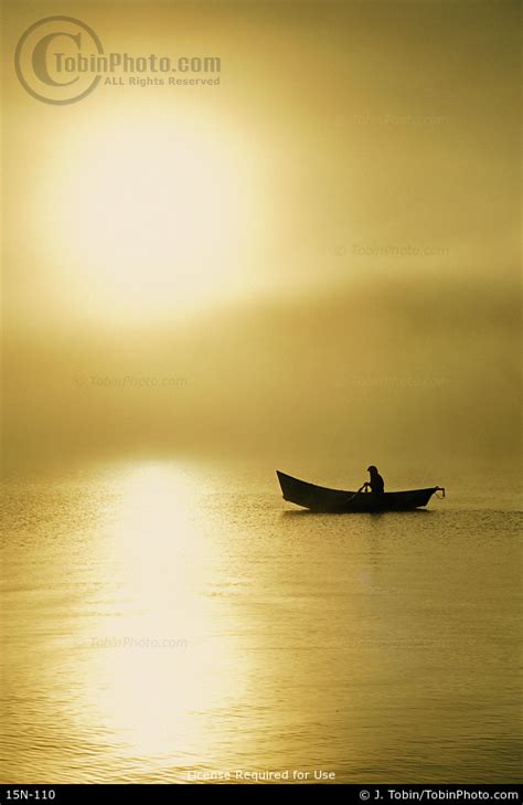 Rowing A Boat In Fog At Sunrise