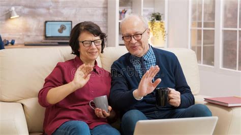Elderly Age Couple Wave At Laptop During A Video Call Stock Image