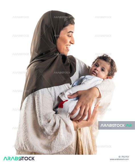 بورتريه لأم عربية خليجية سعودية تحمل طفلها الرضيع بسعادة وحنان، إيماءات تدل الحب والأمان، مفهوم
