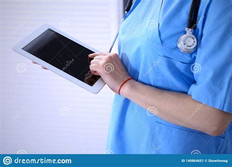 Woman Doctor Using Tablet Computer While Standing Straight In Hospital