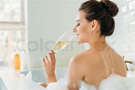 Rear View Of Beautiful Smiling Girl Drinking Wine In Bathtub With Foam Stock Image Colourbox
