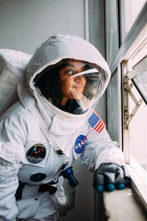 Woman Wearing An Astronaut Costume Looking Out The Window · Free Stock