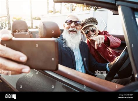 Happy Senior Couple Taking Selfie On New Convertible Car Mature