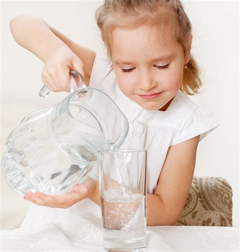 In vielen haushalten werden tee, kaffee und instantgerichte üblicherweise mit dem wasserkocher zubereitet. Child with glass pitcher water - Wasser-Entkalkung