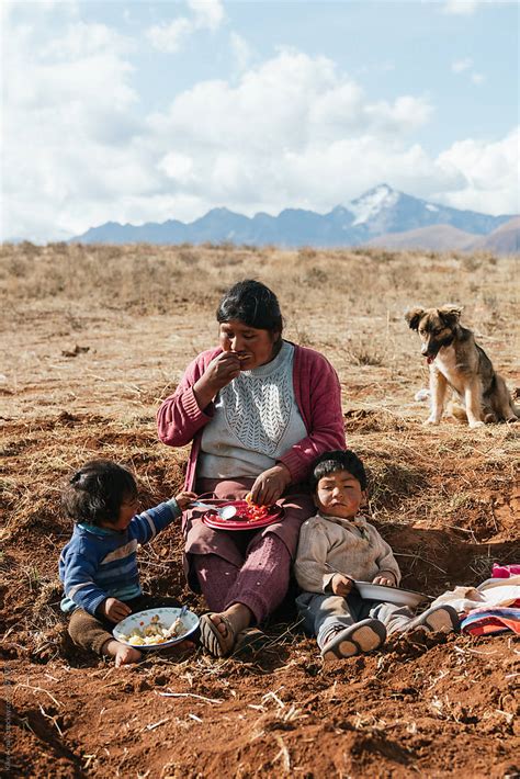 Indigenous Siblings Having Lunch Together In The Mountains Of Peru By