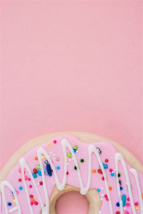 A Donut Or Doughnut Shaped Cookie Against A Pink Background Del Colaborador De Stocksy