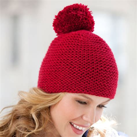 A Woman Wearing A Red Knitted Hat With A Pom Pom