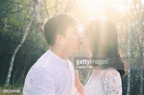Side View Of Young Couple Kissing On Mouth While Standing Outdoors