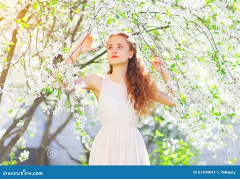 Beautiful Young Woman Enjoying Spring Flowers Over Garden Stock Image