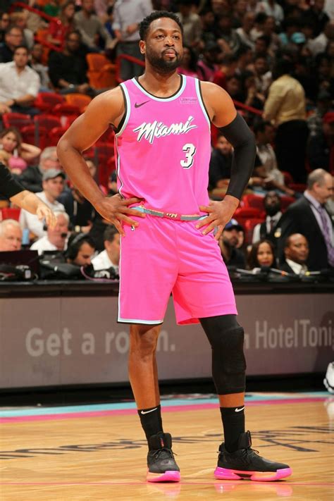 A Man Standing On Top Of A Basketball Court Wearing A Pink Uniform And