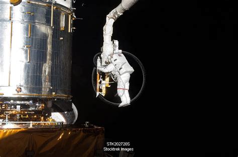 Astronaut Working On The Hubble Space Telescope During A Spacewalk