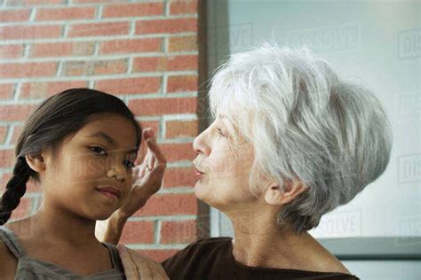 Grandmother Touching Granddaughter S Head Close Up Stock Photo