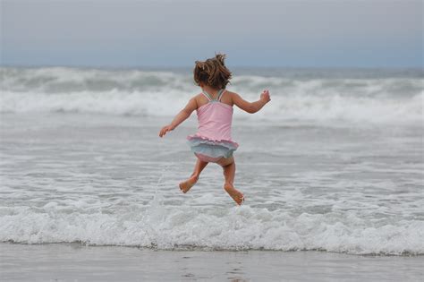 图片素材 海滩 滨 砂 海洋 女孩 玩 支撑 假期 跳跃 溅 儿童 童年 游泳的 水体 俏皮 游泳衣 波浪