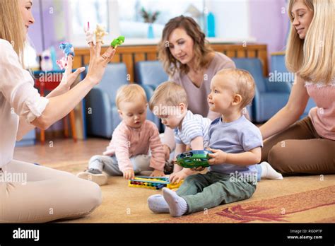 Young Moms And Their Kids Together In Club Babies Play With Musical
