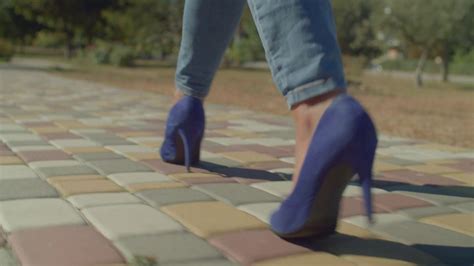 Rear View Of Beautiful Slim Black Female Legs In Stylish Blue High Heel Shoes Walking Along
