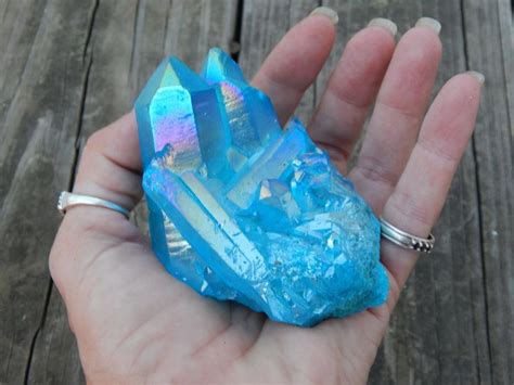 A Person Is Holding A Blue Rock In Their Hand