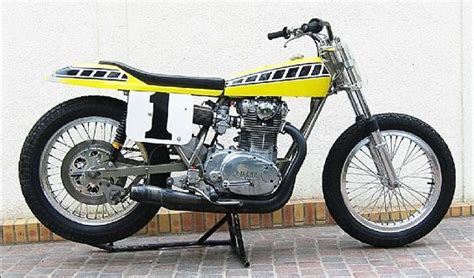 A Yellow And Black Motorcycle Parked On Top Of A Brick Floor Next To A