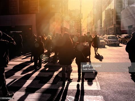 Crowd Of People Walking On Busy City Street Over Sunbeam High Res Stock