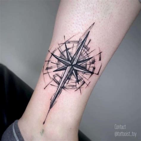 A Compass Tattoo On The Ankle Is Shown In Black And Grey Colors With