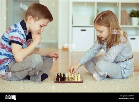 Two Little Children Playing Chess At Home Emotionally Stock Photo Alamy