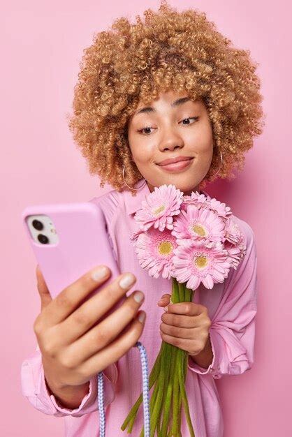 Premium Photo Photo Of Beautiful Woman With Curly Hair Holds Boquet Of Gerberas Takes Selfie