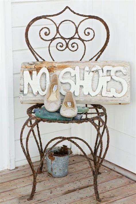 A Wooden Sign That Says No Shoes On Top Of A Small Table With Two Pairs